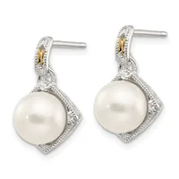 Pair of silver and gold drop earrings with white pearl pendants surrounded by diamond accents and decorative metalwork.