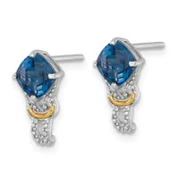 Pair of teardrop-shaped blue topaz stud earrings with textured silver and gold-tone accents, displayed against a white background.
