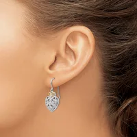 A woman wearing a silver drop earring with an oval filigree design hanging from a hook-style wire, shown from the side view of her ear and neck.
