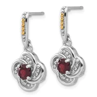 Pair of silver drop earrings with gold accents on the posts, featuring deep red gemstones in ornate four-lobed settings with beaded details.