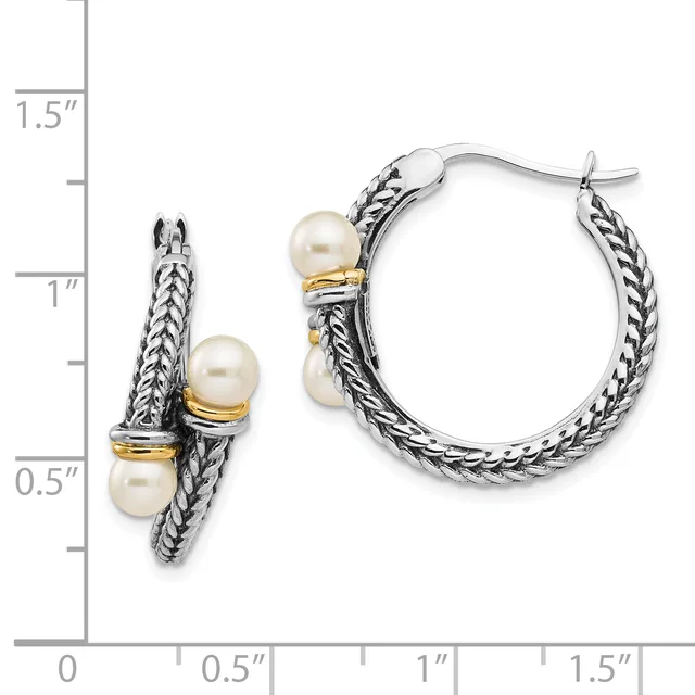 A pair of silver hoop earrings with twisted rope texture and gold-tone accents, each featuring two cream-colored pearl stations, shown next to a measurement scale.