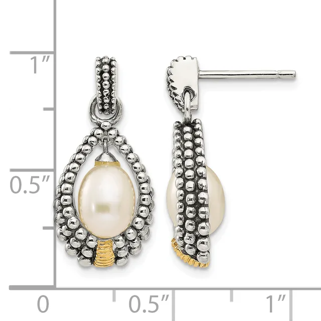 A pair of silver teardrop earrings with beaded borders and cream pearl drops, displayed next to a measurement scale showing approximately one inch in length.