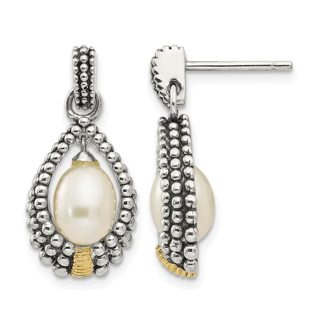 Pair of silver drop earrings with beaded texture, each featuring a cream pearl suspended within an ornamental frame and gold-tone accents at the base.