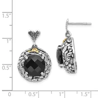 A pair of silver drop earrings with ornate leaf-shaped posts and circular black faceted stone pendants surrounded by decorative metalwork, shown next to a measurement ruler.