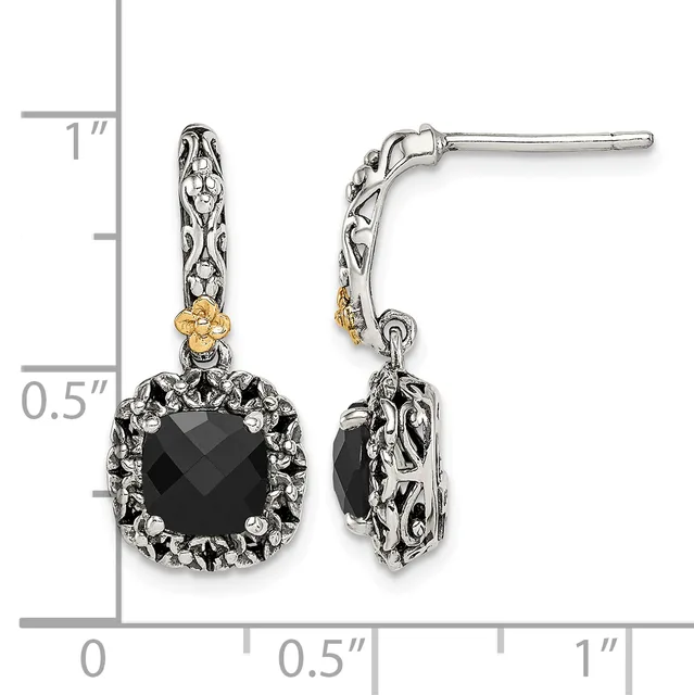 A pair of ornate silver and gold drop earrings with black faceted square stones surrounded by decorative metalwork, shown next to a measurement scale.