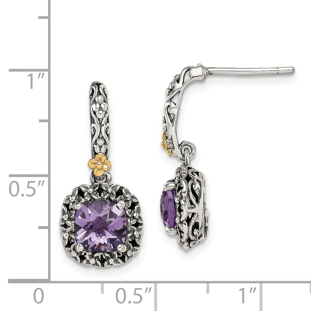 A pair of silver and gold drop earrings with purple cushion-cut gemstones surrounded by ornate metalwork, displayed against a measurement scale.