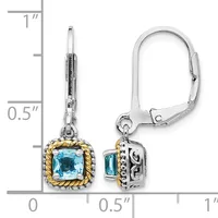 Pair of silver and gold-toned leverback earrings with cushion-cut blue topaz stones, shown next to a ruler measuring approximately one inch in length.