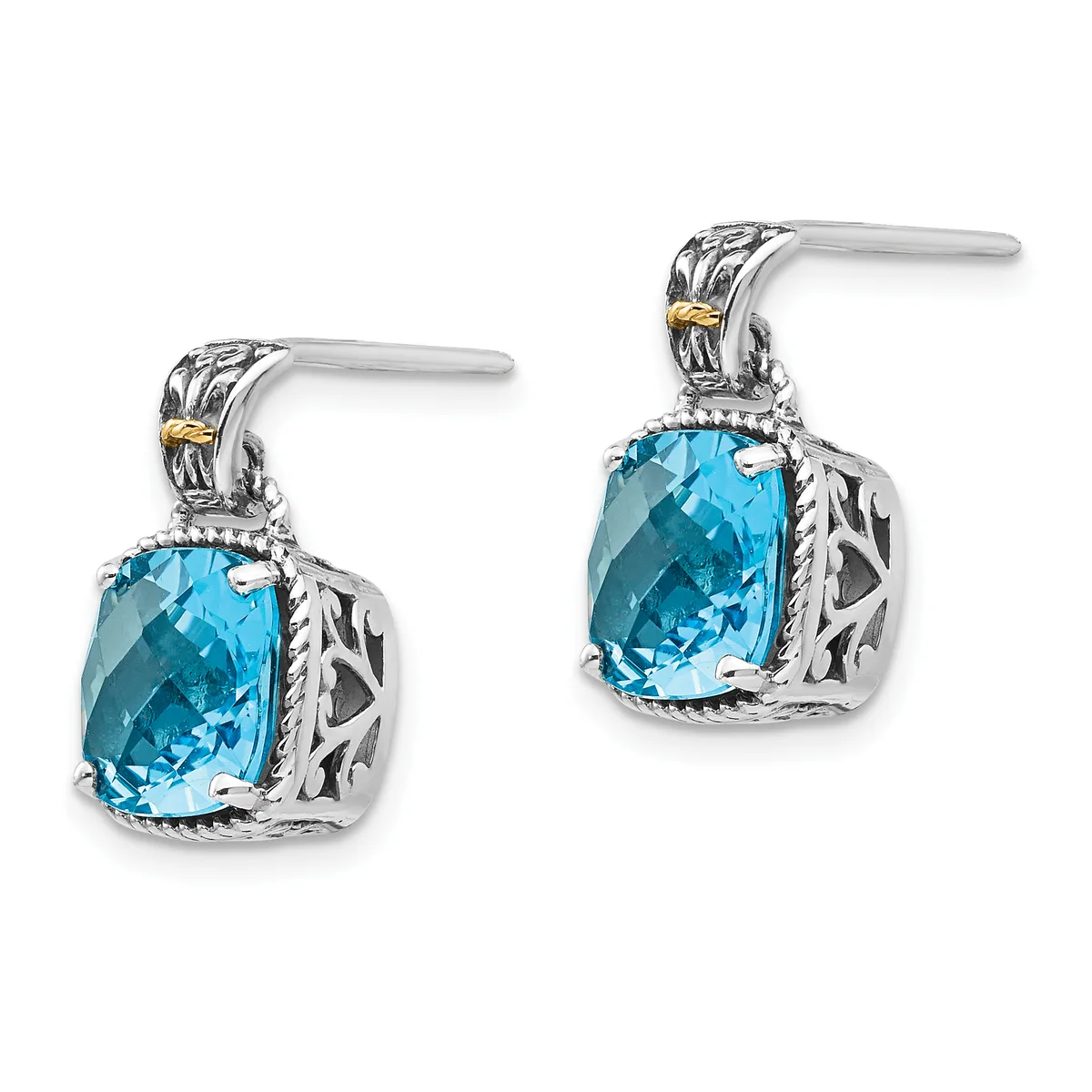 A pair of sterling silver drop earrings with cushion-cut blue topaz stones set in ornate filigree settings with gold accents on the posts.