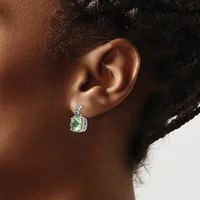 A person wearing a silver earring with a green square stone surrounded by small diamonds, shown from the side profile against a neutral background.