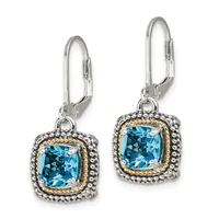A pair of silver and gold-toned drop earrings with cushion-cut blue topaz stones surrounded by decorative beaded borders, displayed against a white background.