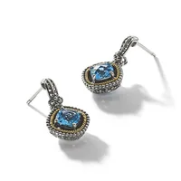 Pair of silver and gold-toned drop earrings with cushion-cut blue topaz stones set in ornate frames with beaded borders and decorative posts.