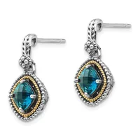 A pair of silver drop earrings with gold-tone twisted rope borders, each featuring a faceted blue topaz stone in an ornate cushion-shaped setting with decorative lion head details above.