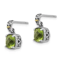 A pair of silver dangle earrings with ornate filigree posts, each featuring a cushion-cut peridot stone in an ornamental square setting with gold accents.