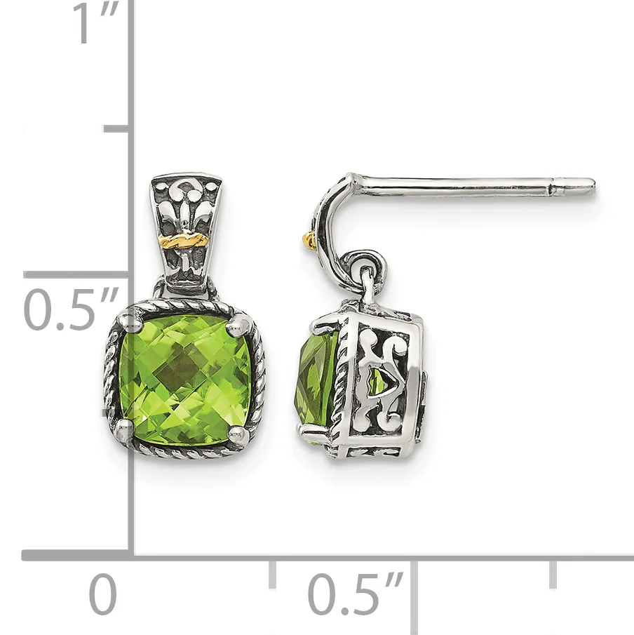 Pair of silver and gold dangle earrings with cushion-cut peridot stones, displayed on a measurement scale showing approximately one inch in length.