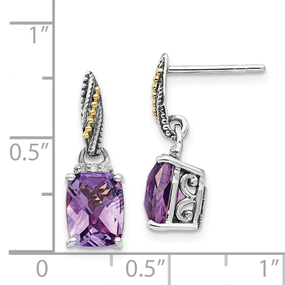 A pair of silver dangle earrings with purple cushion-cut amethyst stones set in ornate frames with gold-accented twisted details, shown next to a measurement scale.