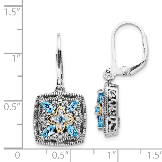 A pair of square ornamental earrings with blue gemstones arranged in a four-pointed star pattern and gold-toned center detail, shown next to a ruler for scale.