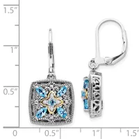 A pair of square ornamental earrings with blue gemstones arranged in a four-pointed star pattern and gold-toned center detail, shown next to a ruler for scale.