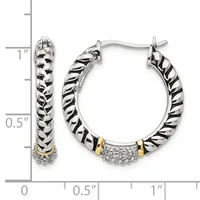 A pair of two-tone hoop earrings with twisted silver texture, gold accents, and diamond pave sections at the bottom, displayed next to a measurement ruler.