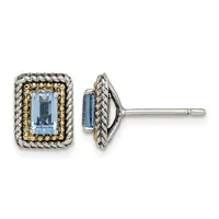 Pair of rectangular stud earrings with light blue faceted stones set in two-tone metal with twisted rope and beaded borders, shown from front and side views.