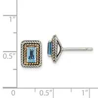 A pair of rectangular stud earrings with light blue faceted stones surrounded by twisted metalwork borders, shown next to a measurement scale.