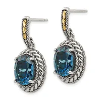 Pair of silver dangle earrings with twisted rope detailing, gold accents on the posts, and oval-cut blue topaz stones set in ornate frames.