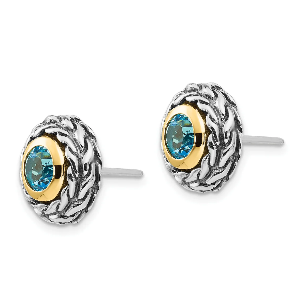 A pair of oval stud earrings featuring blue gemstones set in gold bezels surrounded by ornate twisted silver frames, shown from the front.