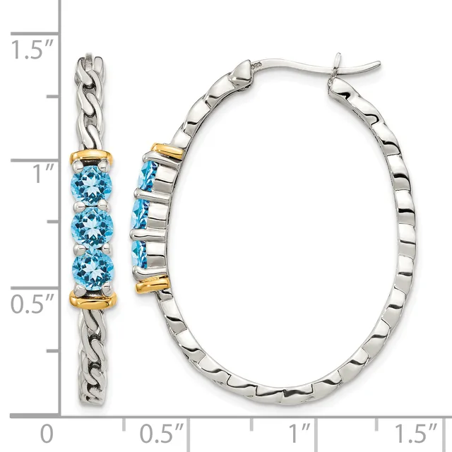 A pair of silver hoop earrings with three blue topaz stones and gold-tone accents, displayed next to a measurement scale showing approximately 1.5 inches in length.