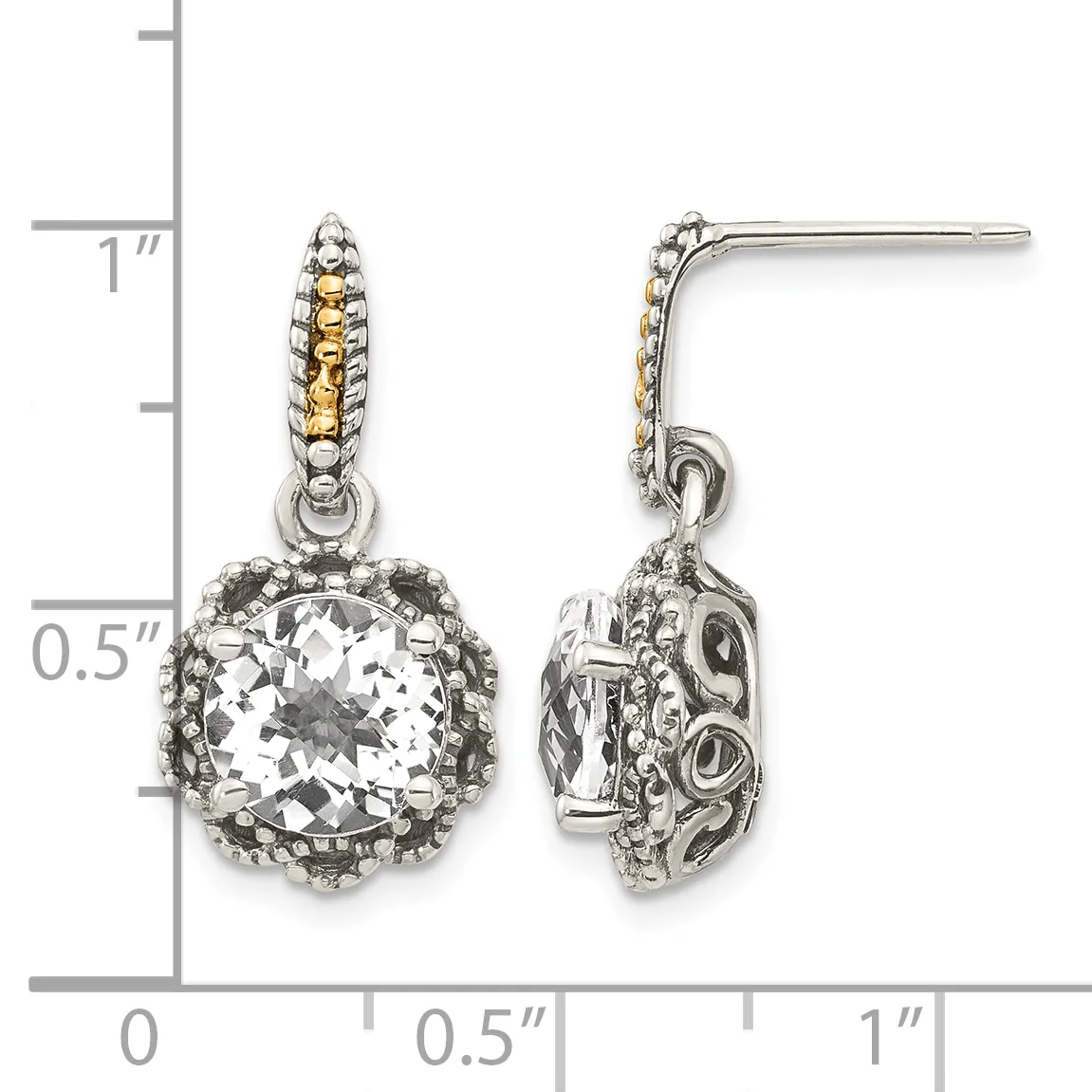 A pair of two-tone dangle earrings with cushion-cut clear stones surrounded by ornate metalwork and textured posts, shown against a measurement scale.