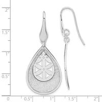 A pair of silver teardrop earrings with textured outer surfaces and cutout flower designs on the inner pendants, shown next to a ruler measuring approximately two inches in length.