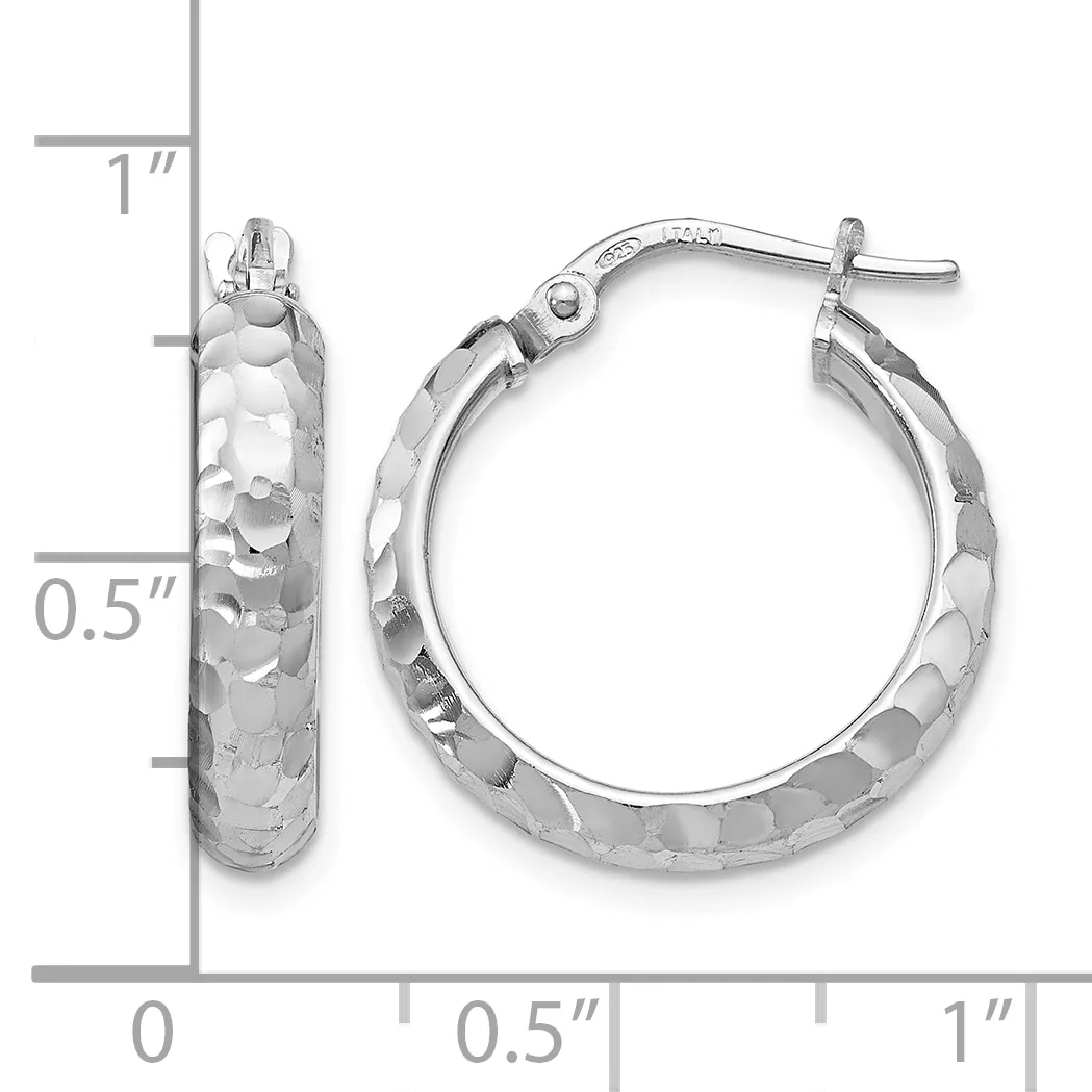A pair of silver hoop earrings with a textured hammered surface, shown next to a ruler indicating they are approximately one inch in diameter.