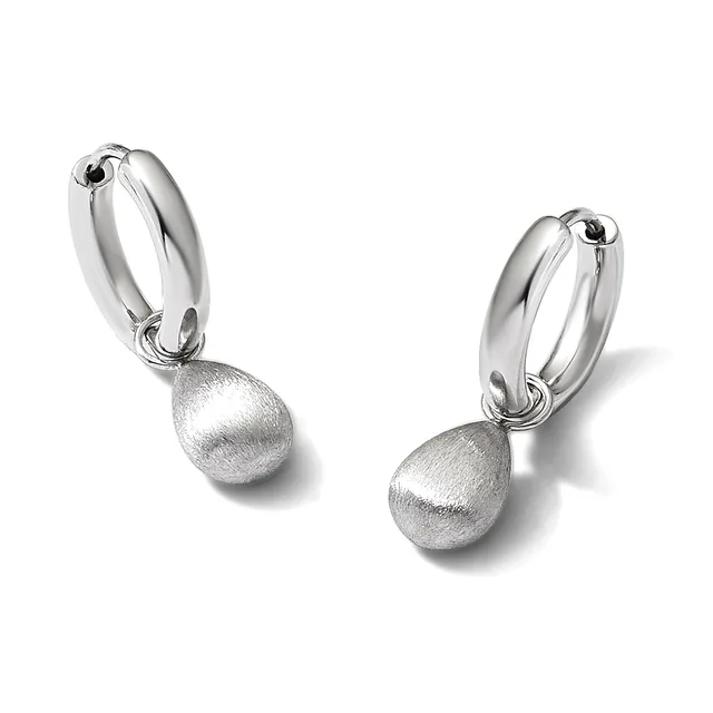 A pair of silver hoop earrings with matte finish spherical pendants hanging from polished curved hoops.