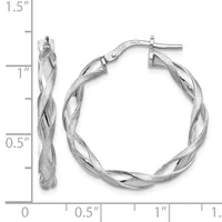 A pair of silver twisted hoop earrings with post and clutch backs, shown against a ruler measuring approximately 1.5 inches in length.