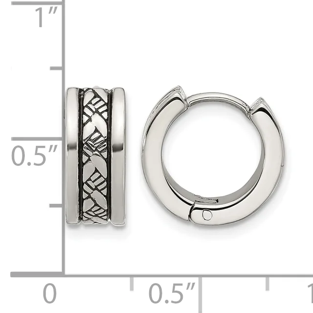 A pair of silver hinged hoop earrings with a textured crosshatch pattern on the outer band, shown next to a measurement scale indicating approximately one inch in height and half inch in width.