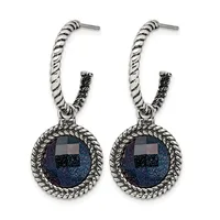 Pair of silver-toned hoop earrings with twisted rope texture and dark blue gemstone pendants in ornate circular settings.