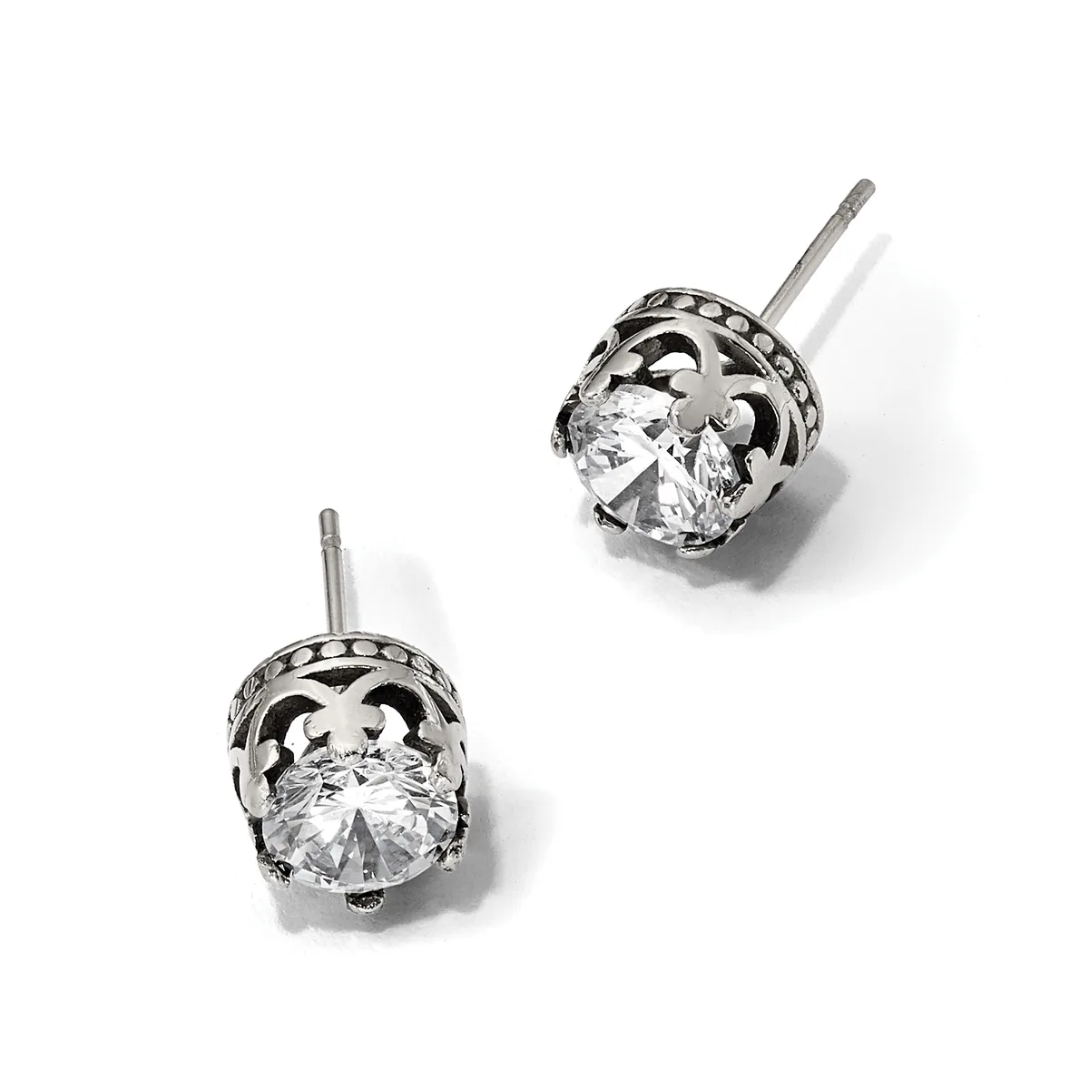 A pair of silver stud earrings with ornate filigree settings holding round brilliant-cut clear gemstones, displayed against a white background.