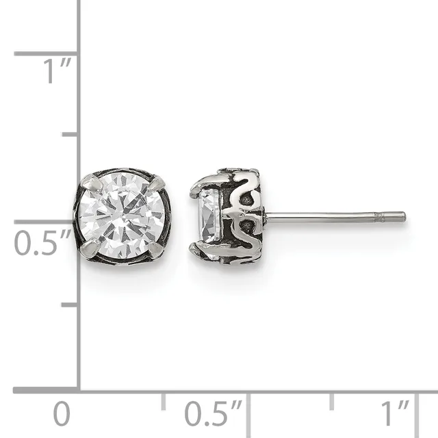 Pair of silver stud earrings with round clear cubic zirconia stones in decorative settings, displayed against a measurement ruler.