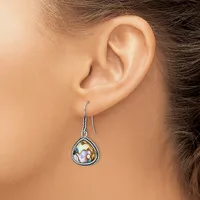 A woman wearing a teardrop-shaped dangle earring with an iridescent stone center surrounded by a beaded silver-tone metal frame.