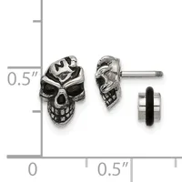 Pair of silver skull stud earrings with detailed facial features shown front and side view against a measurement scale.