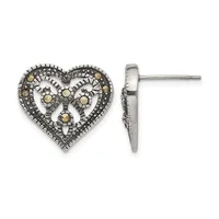 A pair of ornate heart-shaped stud earrings in silver and gold with filigree detailing and small round stone accents, shown from front and side views.