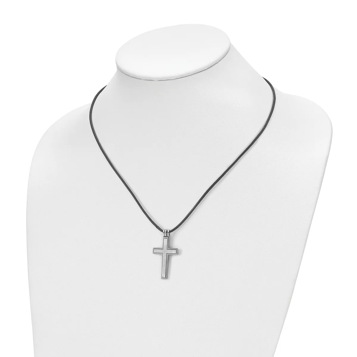 A silver-toned cross pendant hangs from a dark cord on a white mannequin bust displaying necklace jewelry.
