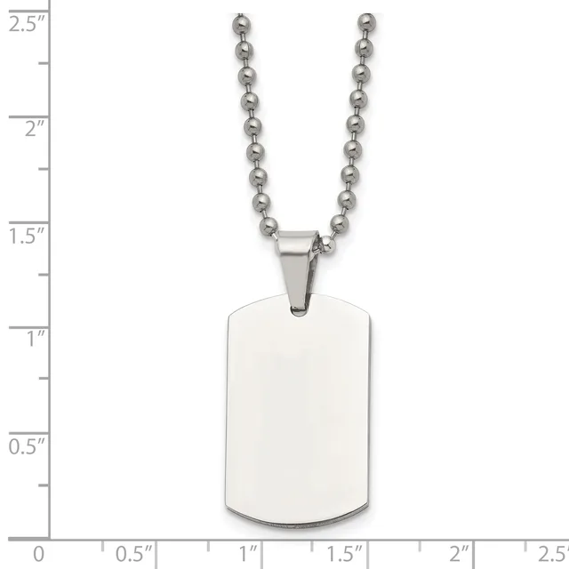 A stainless steel dog tag pendant with rounded corners hangs from a ball chain, shown against a measurement scale indicating the tag is approximately 1.5 inches tall.