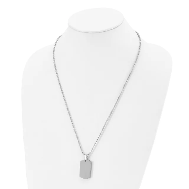A silver-toned rectangular pendant hangs from a delicate chain on a white mannequin bust.