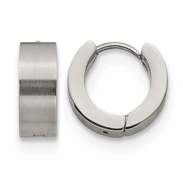A pair of polished silver huggie hoop earrings shown from the front and side, displaying their chunky cylindrical design and hinged closure.