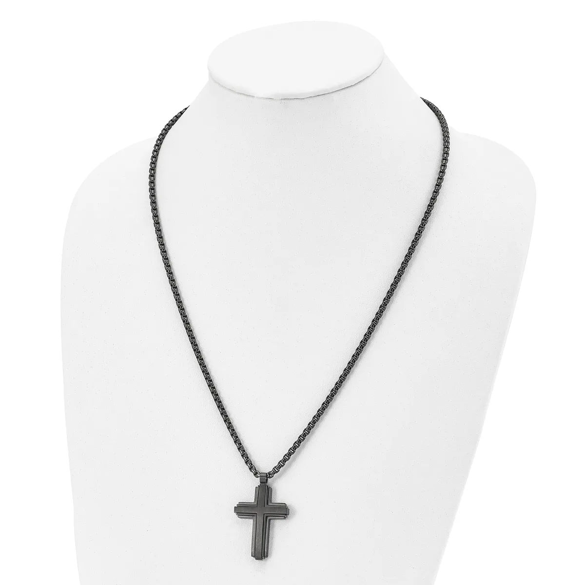 Black metal cross pendant hanging from a black beaded chain necklace, displayed on a white mannequin bust.