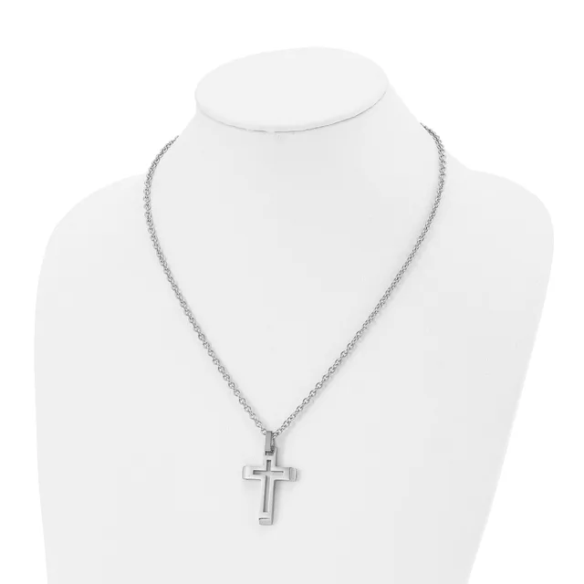 A silver-toned cross pendant hangs from a delicate chain necklace displayed on a white mannequin bust.