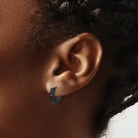 A person wearing a small dark hoop earring in their earlobe, shown in profile against a neutral background.