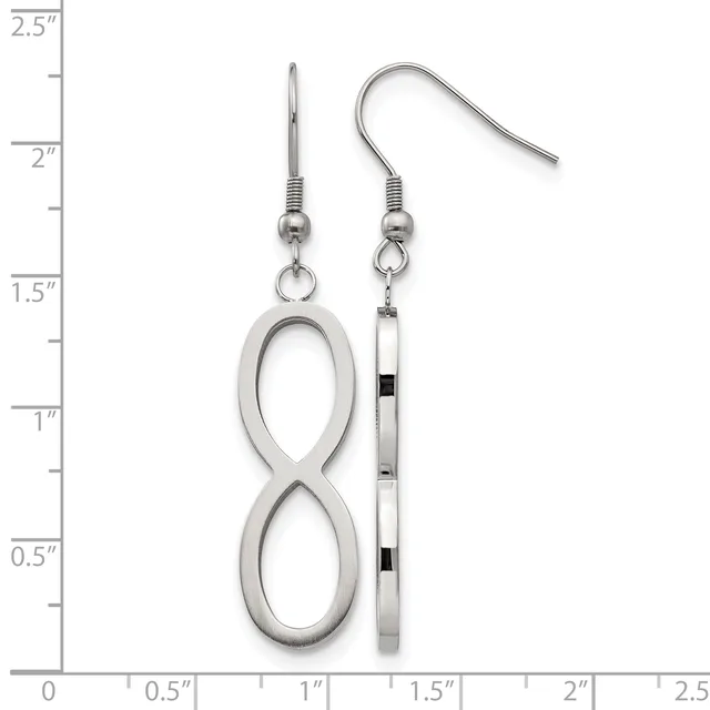 Two silver-toned dangle earrings displayed against a ruler: one featuring an infinity symbol, the other a rectangular bar with black accents, both with wire hooks.