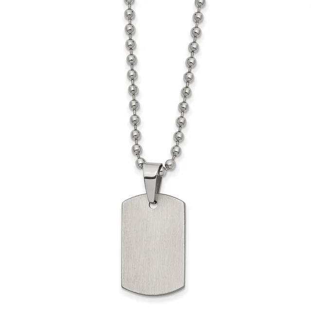 A brushed stainless steel dog tag pendant hangs from a ball chain necklace against a white background.