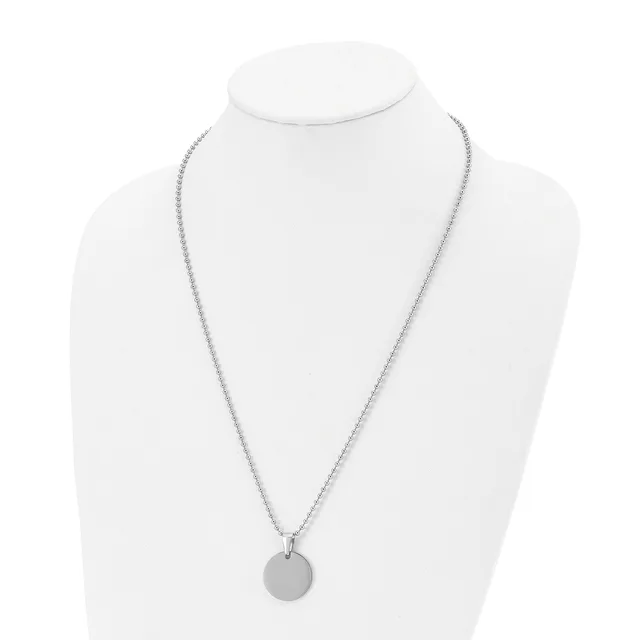 A silver-toned chain necklace with a small circular pendant displayed on a white bust form.