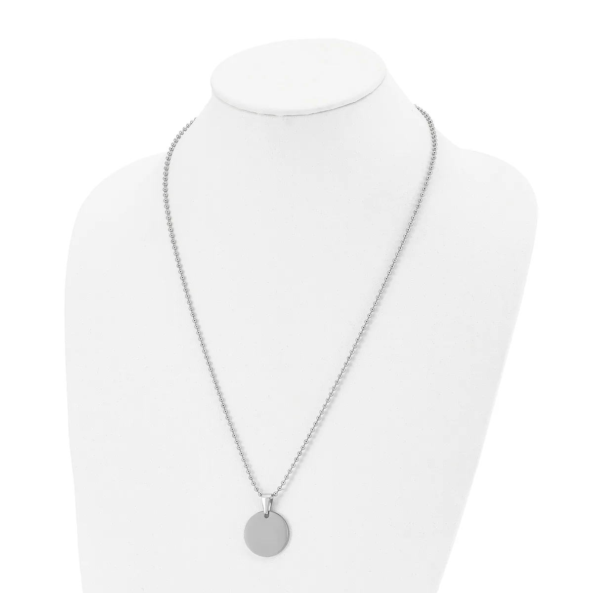A silver-toned chain necklace with a small circular pendant displayed on a white bust form.
